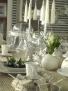 Stół zastawiony dekoracjami - białe talerze, kwietniki, stojaki na torty