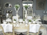 Pokój pełen różnorodnego rodzaju dekoracji. Biała zastawa, kwietniki, świeczniki, poduszki oraz artystyczne meble.